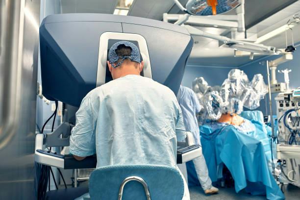 robotic thyroid surgery Surgeon seated at a robotic surgery console in an operating room.
