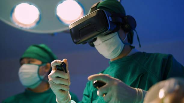 robotic thyroid surgery Surgeon in operating room wearing a VR headset and mask, holding surgical controllers.
